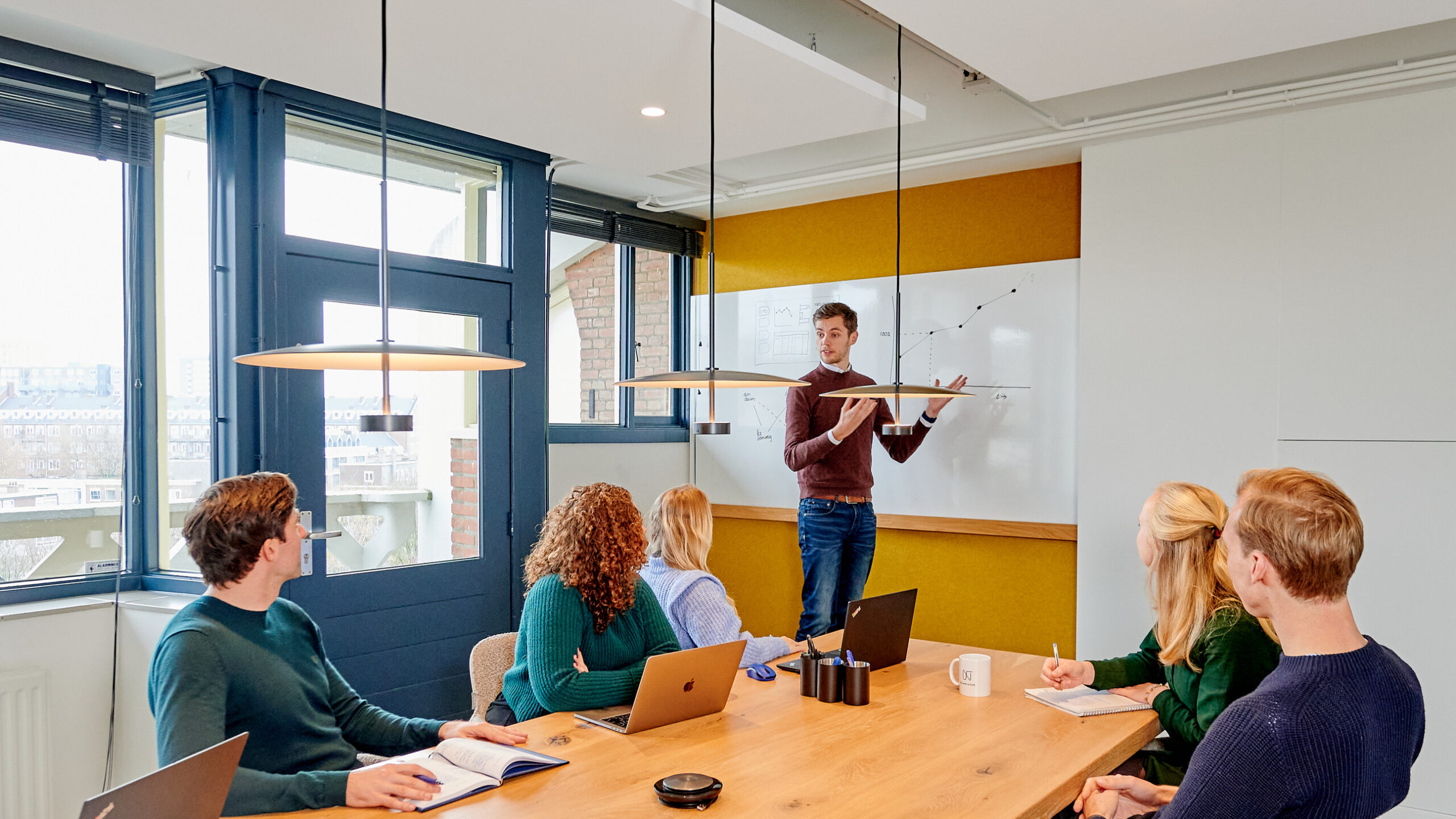 Een foto van een team in overleg. Ter illustratie van een tekst over samenwerking. De sleutel tot succes. Als creatieve partners komen we in behapbare stappen tot de oplossing.